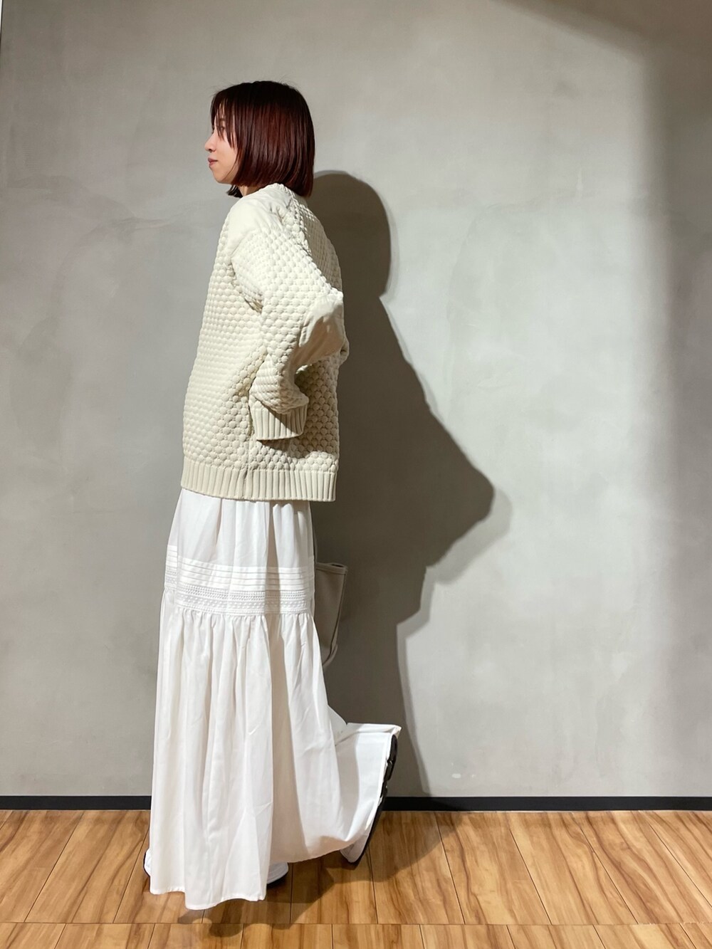 ベージュ系のニット/セーター、ホワイト系のスカートを着用したレディースの秋コーディネートの5枚目の写真