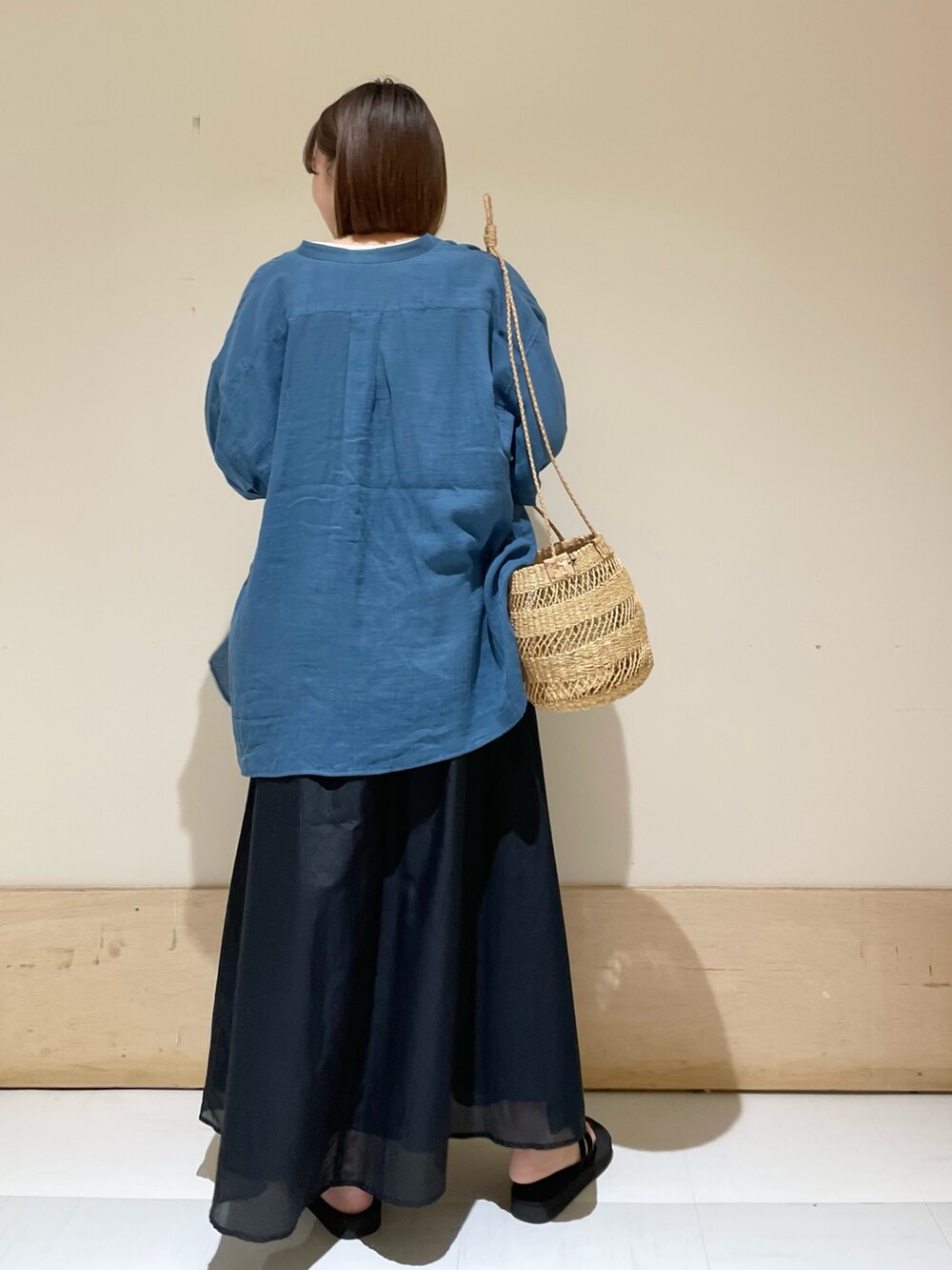 ブラック系のスカート、ベージュ系のショルダーバッグ、グレー系のTシャツ/カットソーを着用したレディースの夏コーディネートの6枚目の写真