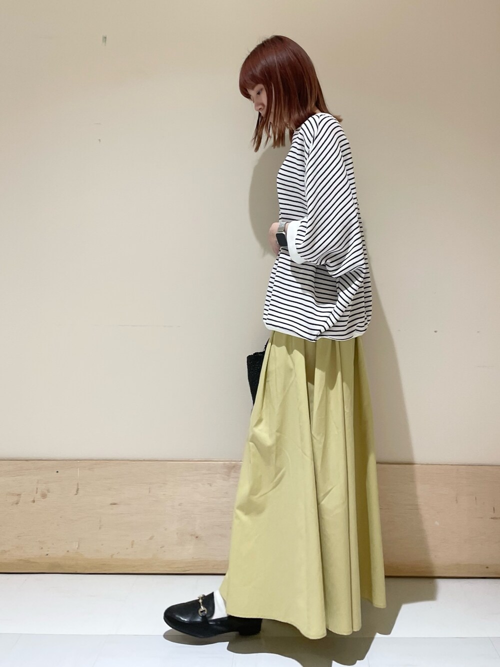 ホワイト系のTシャツ/カットソー、イエロー系のスカート、ブラック系のローファーを着用したレディースの春コーディネートの3枚目の写真