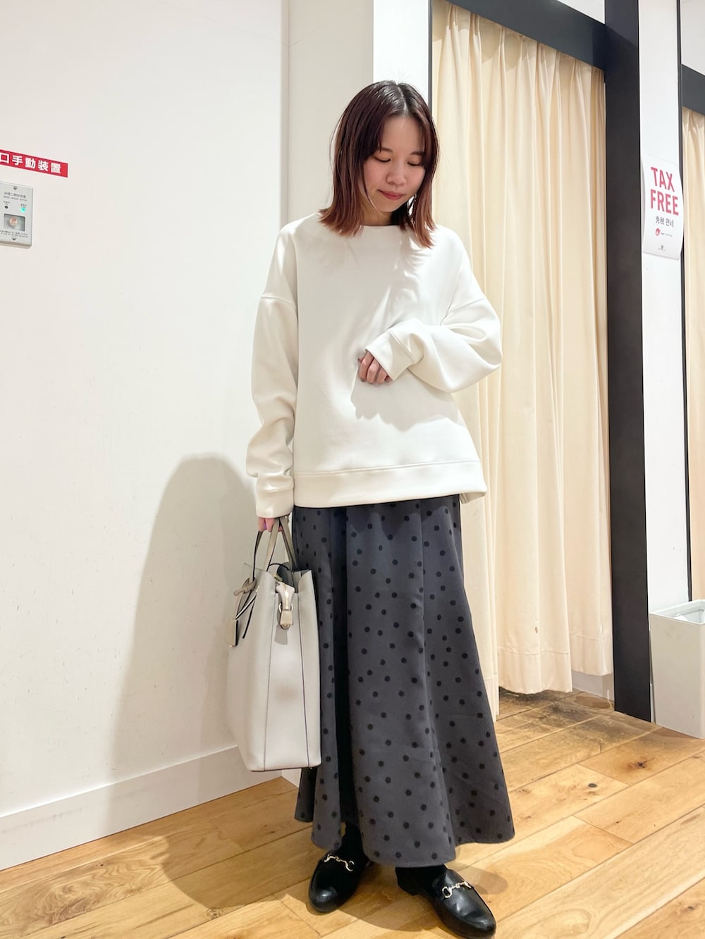 ホワイト系のTシャツ/カットソー、グレー系のスカートを着用したレディースの春コーディネートの3枚目の写真