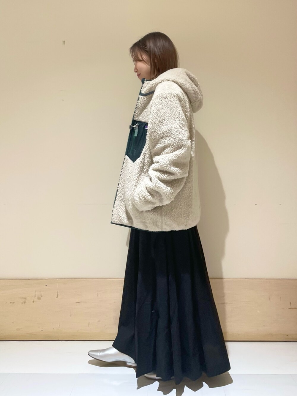 シルバー系のパンプス、ブルー系のTシャツ/カットソー、ベージュ系のハンドバッグを着用したレディースの秋コーディネートの5枚目の写真