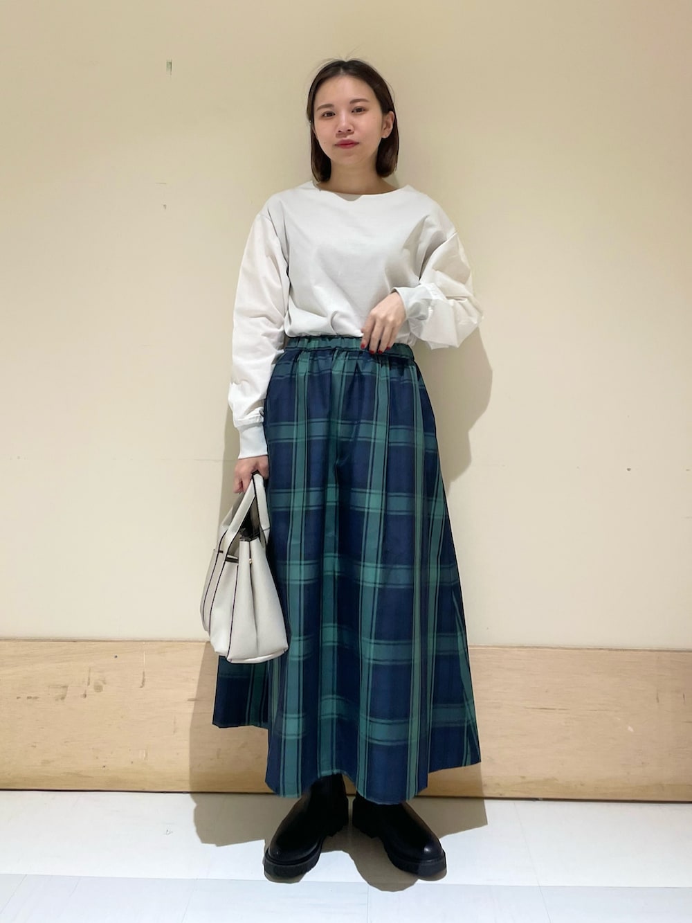 グレー系のTシャツ/カットソー、ブルー系のスカート、グレー系のトートバッグを着用したレディースの秋コーディネートの6枚目の写真