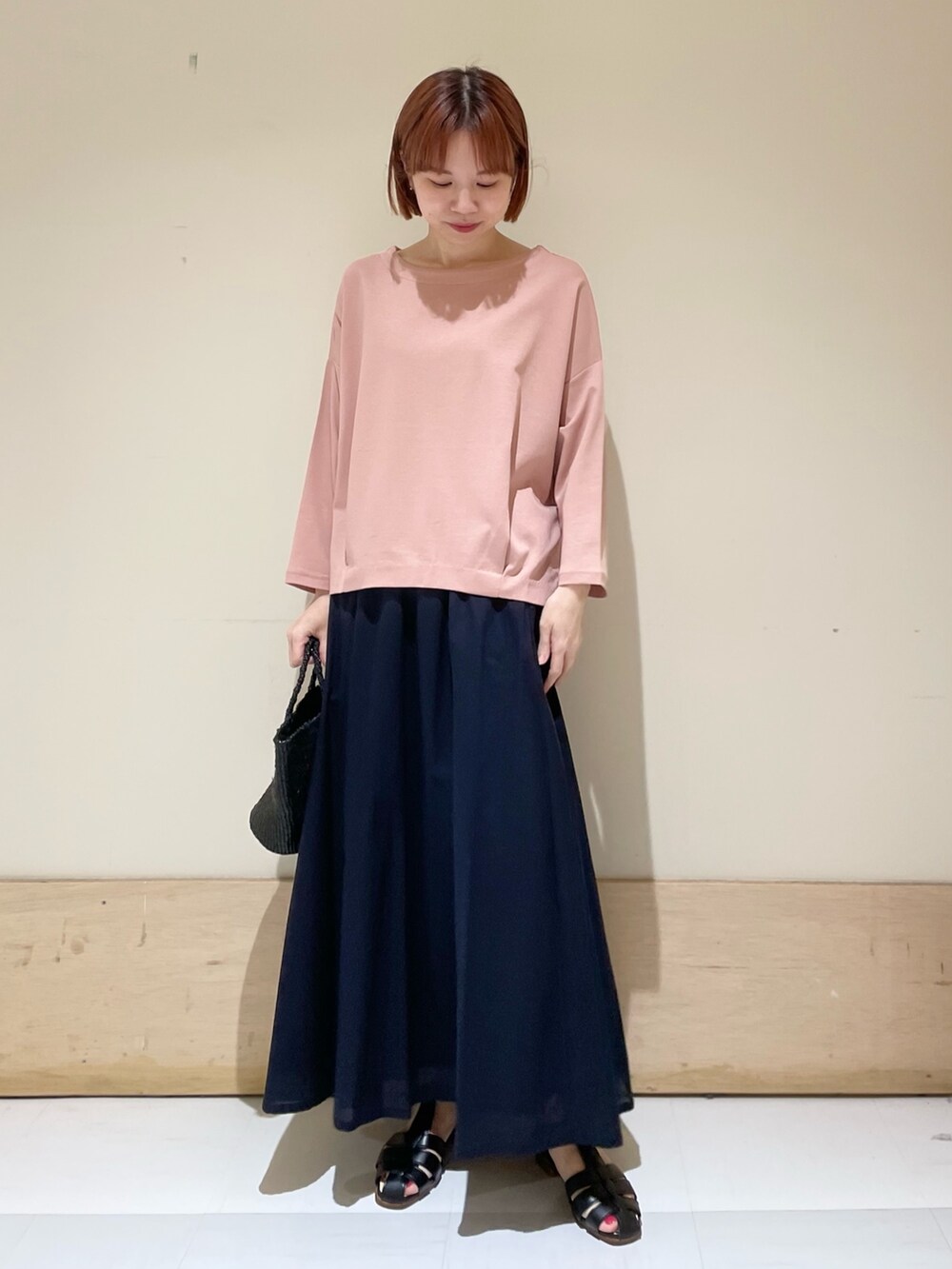 ピンク系のTシャツ/カットソー、ブルー系のスカート、ブラック系のハンドバッグを着用したレディースの春コーディネートの4枚目の写真