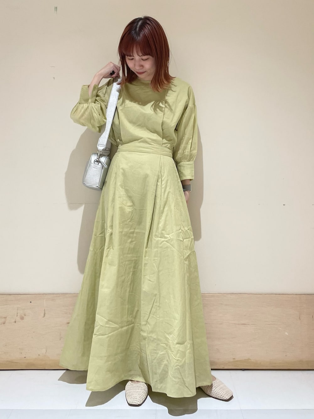 グリーン系のワンピース、シルバー系のショルダーバッグ、ホワイト系のパンプスを着用したレディースの春コーディネートの3枚目の写真