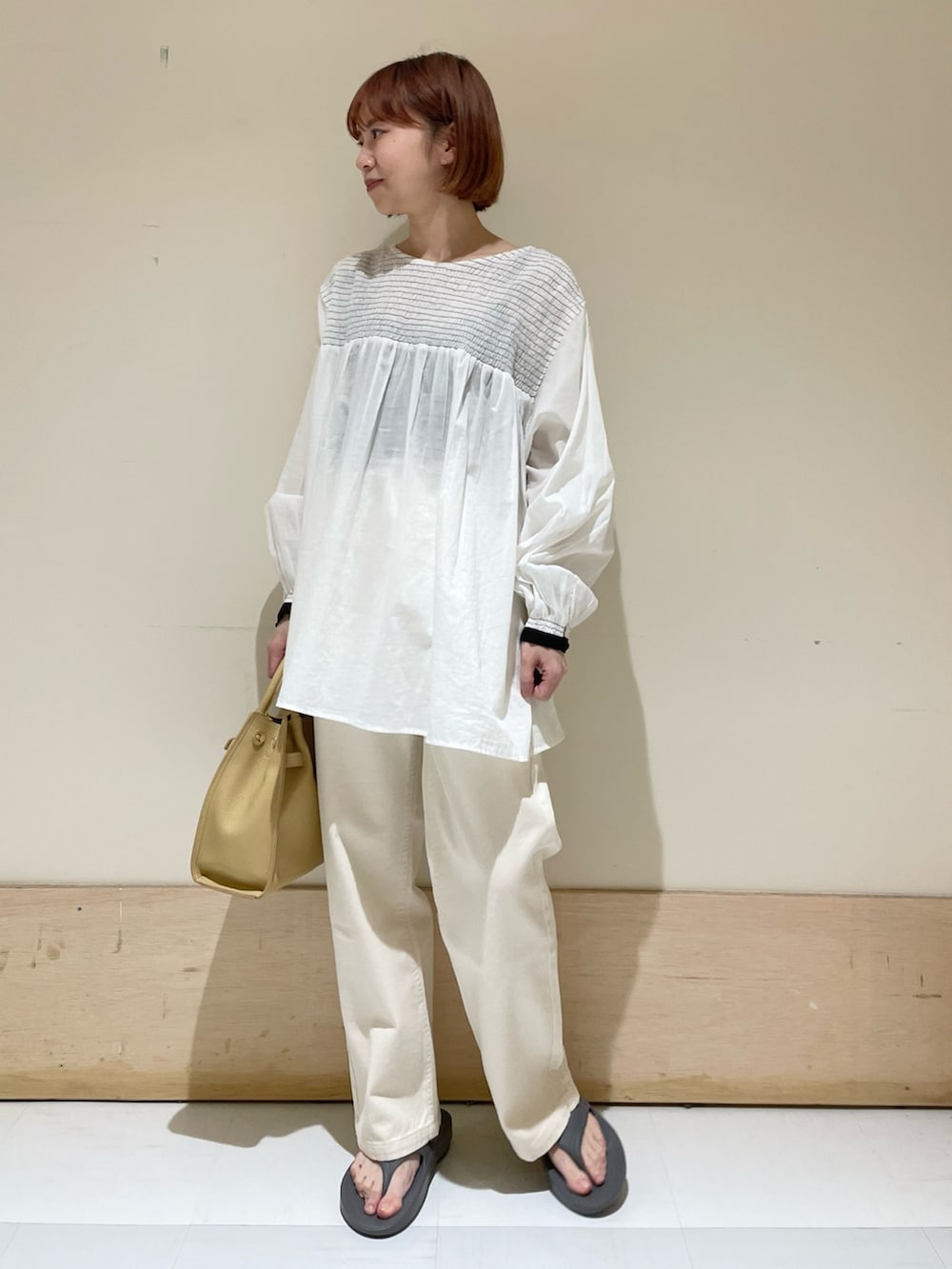 グレー系のサンダル、イエロー系のトートバッグ、ホワイト系のシャツ/ブラウスを着用したレディースの春コーディネートの3枚目の写真