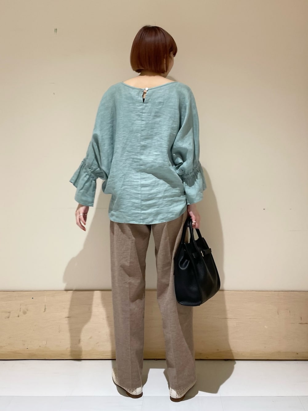 グリーン系のシャツ/ブラウス、ブラック系のトートバッグ、ホワイト系のバレエシューズを着用したレディースの春コーディネートの8枚目の写真