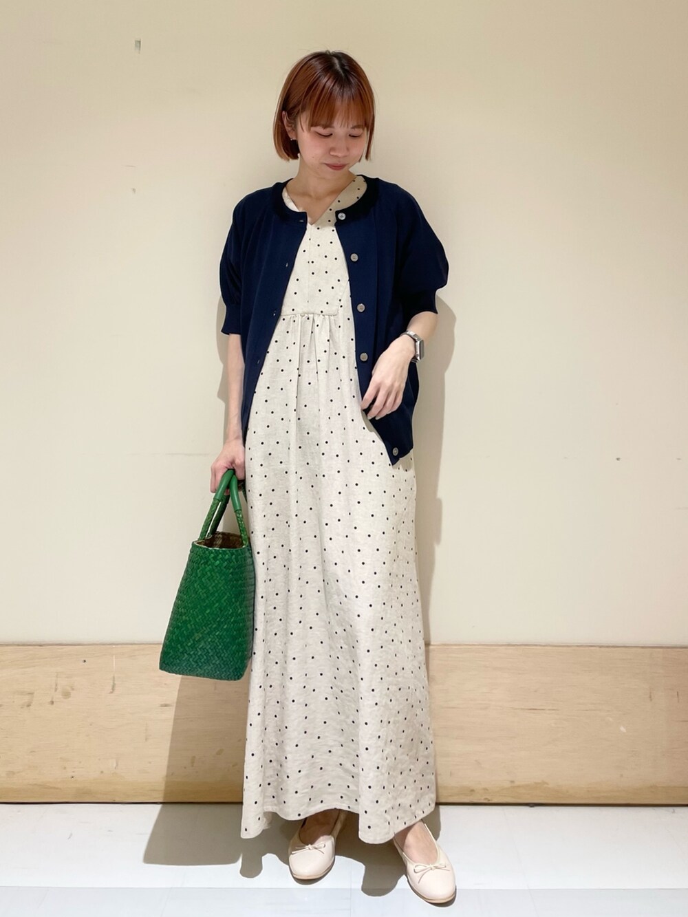 ベージュ系のワンピース、ブルー系のカーディガン/ボレロ、ピンク系のバレエシューズを着用したレディースの春コーディネートの2枚目の写真