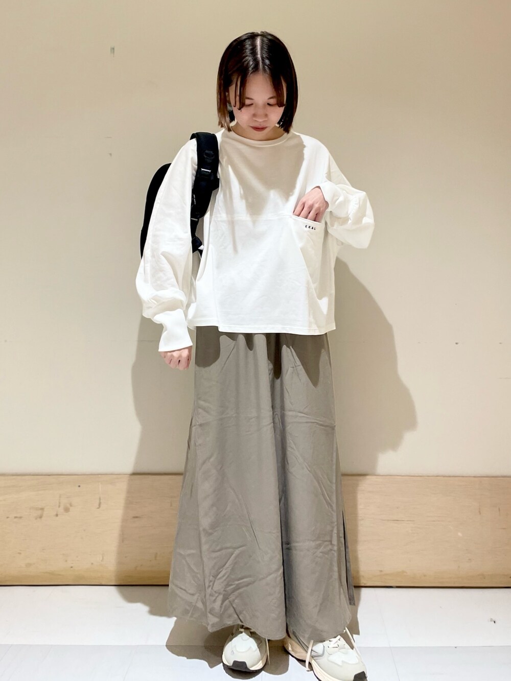 ホワイト系のTシャツ/カットソー、グリーン系のスカート、グレー系のスニーカーを着用したレディースの夏コーディネートの2枚目の写真