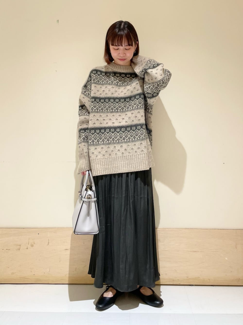 ベージュ系のニット/セーター、グレー系のスカート、ブラック系のその他シューズを着用したレディースの冬コーディネートの4枚目の写真