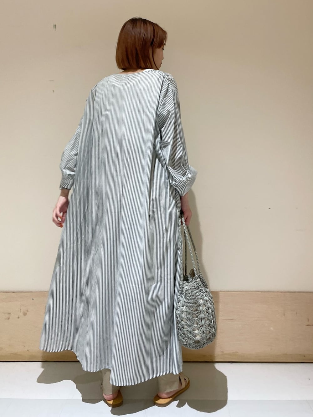 グリーン系のワンピース、グリーン系のかごバッグ、ベージュ系のその他パンツを着用したレディースの夏コーディネートの6枚目の写真