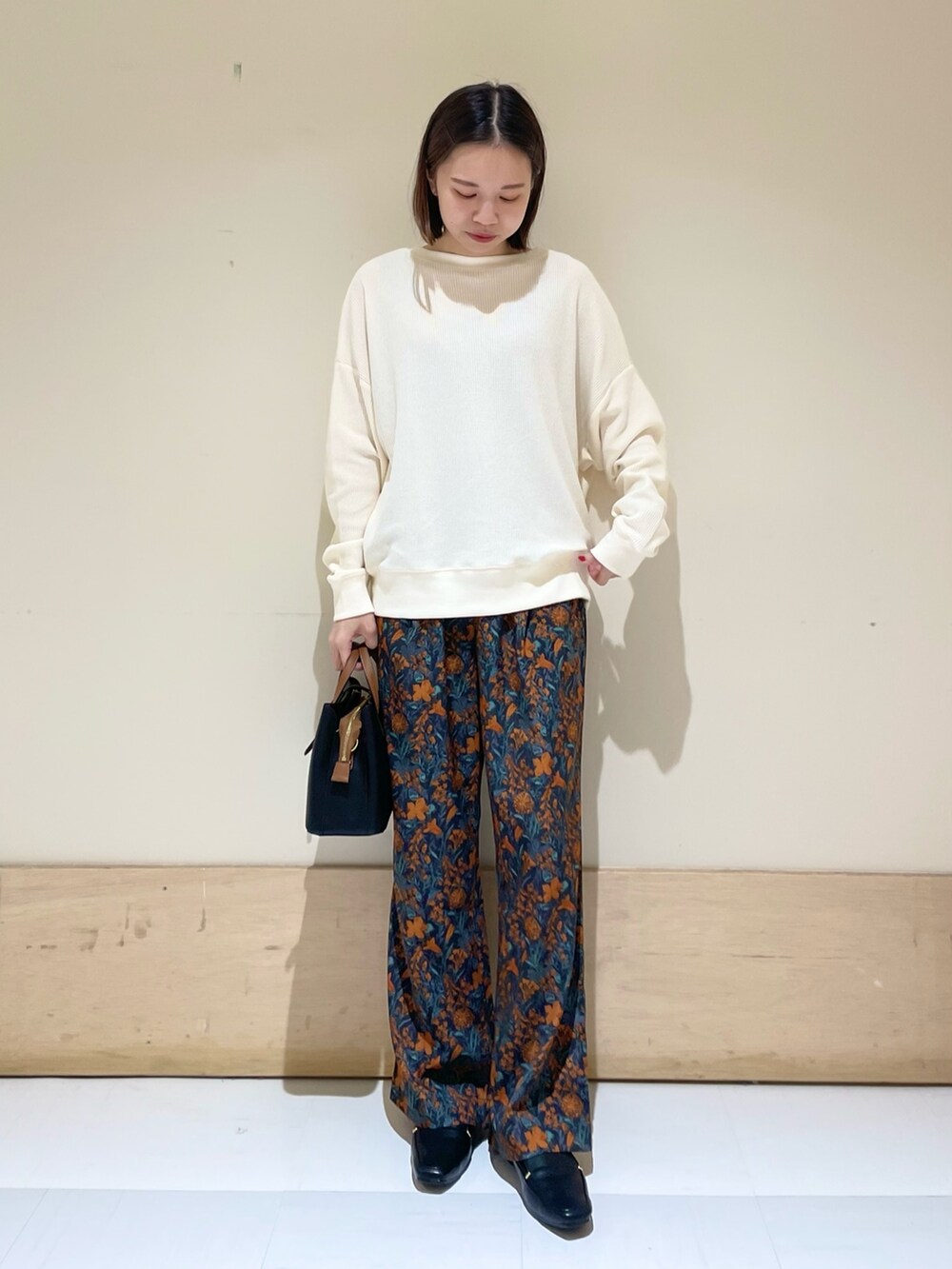 オレンジ系のその他パンツ、ブラック系のハンドバッグ、ブラック系のローファーを着用したレディースの秋コーディネートの4枚目の写真