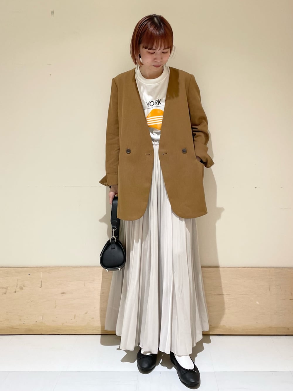 ベージュ系のノーカラージャケット、ブラック系のショルダーバッグ、ブラック系のバレエシューズを着用したレディースの春コーディネートの2枚目の写真