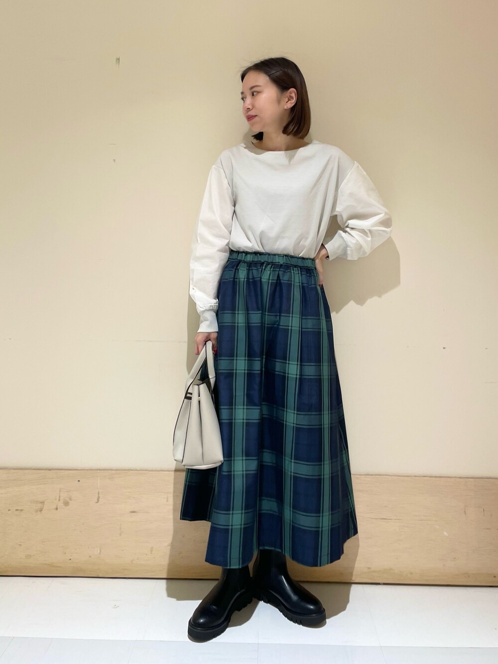 グレー系のTシャツ/カットソー、ブルー系のスカート、グレー系のトートバッグを着用したレディースの秋コーディネートの2枚目の写真