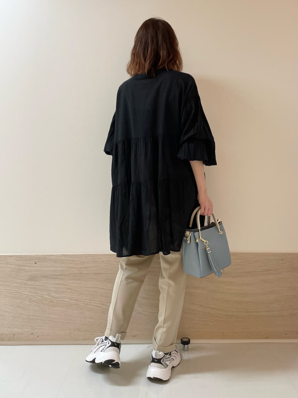 ブラック系のチュニック、ベージュ系のその他パンツを着用したレディースの春コーディネートの8枚目の写真