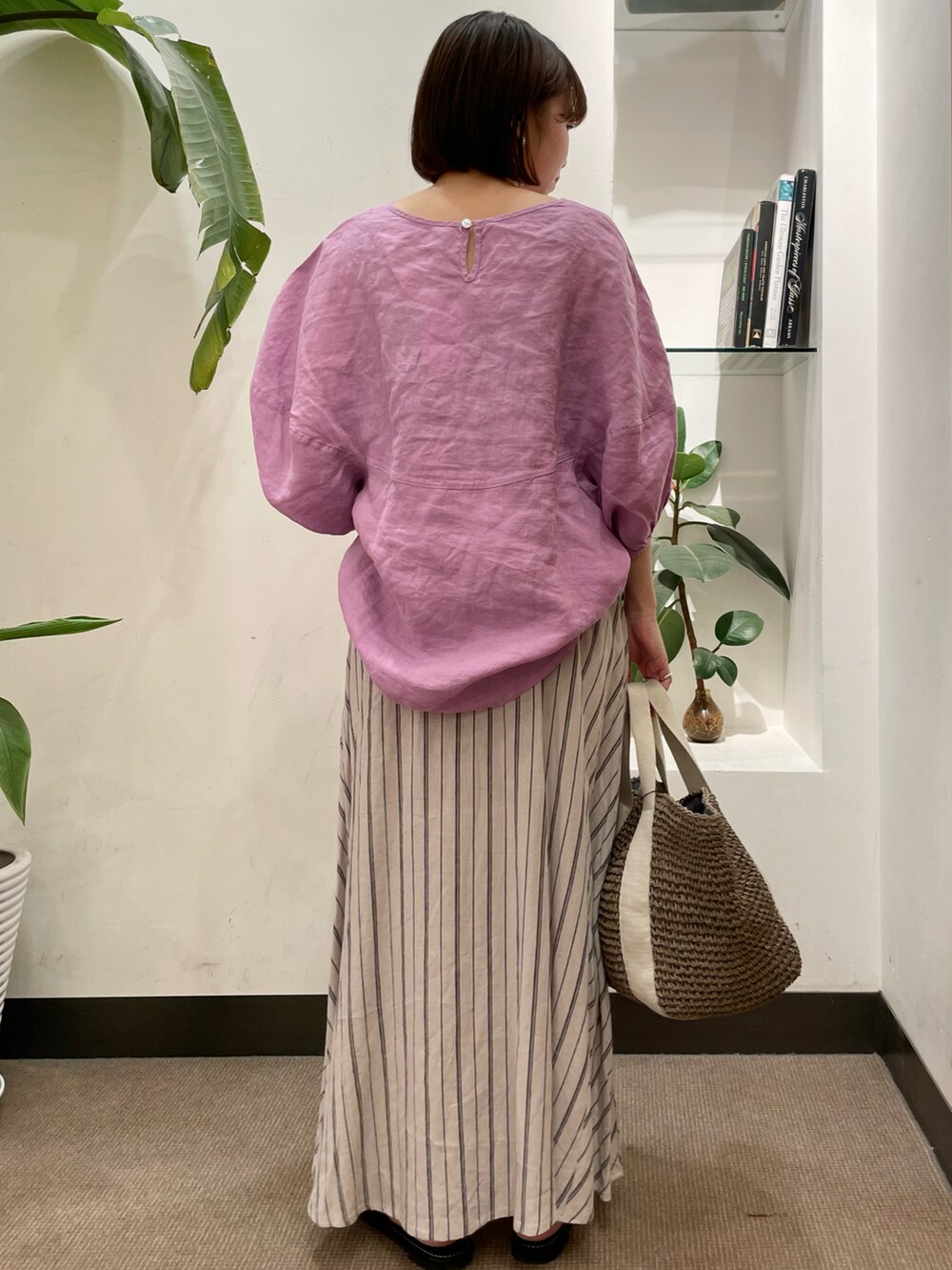 グレー系のトートバッグ、ベージュ系のスカート、パープル系のシャツ/ブラウスを着用したレディースの夏コーディネートの3枚目の写真