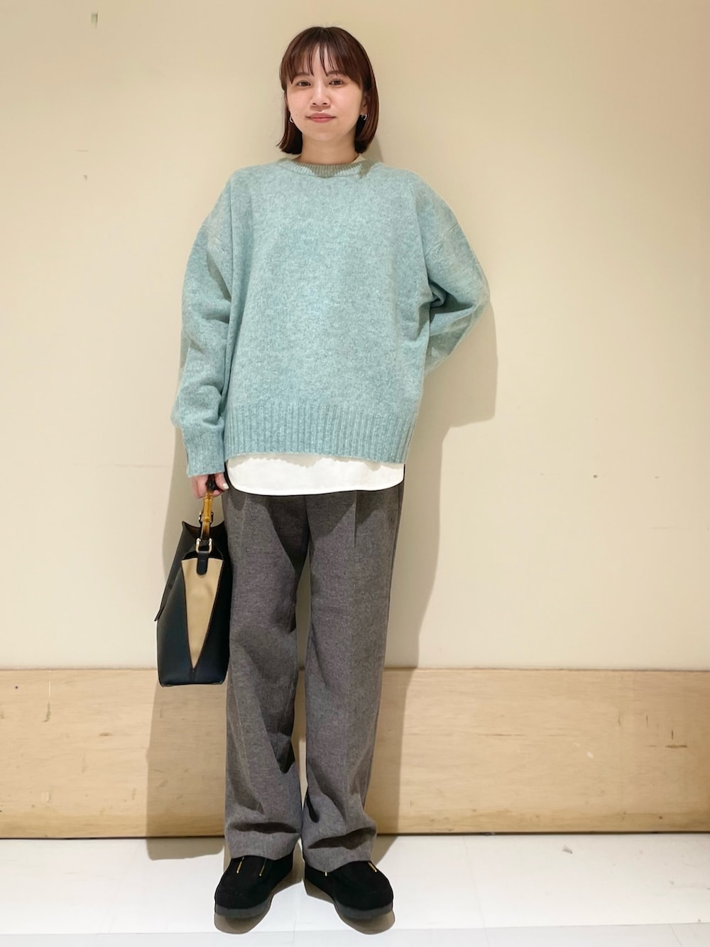 グリーン系のニット/セーター、ホワイト系のTシャツ/カットソー、グレー系のその他パンツを着用したレディースの冬コーディネートの2枚目の写真