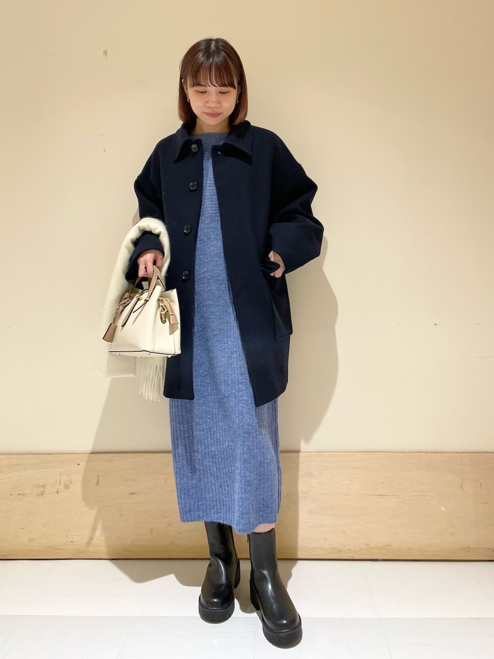 ブルー系のワンピース、ブルー系のその他アウター、ブラック系のブーツを着用したレディースの冬コーディネートの2枚目の写真