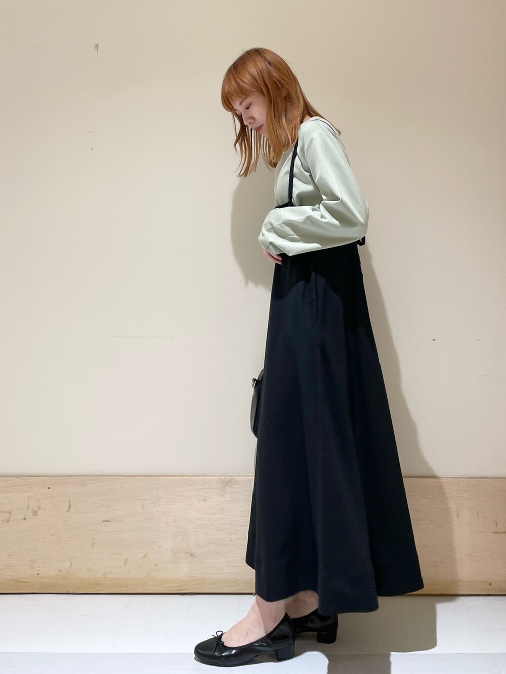 グリーン系のTシャツ/カットソー、ブラック系のバレエシューズ、ブラック系のショルダーバッグを着用したレディースの春コーディネートの4枚目の写真
