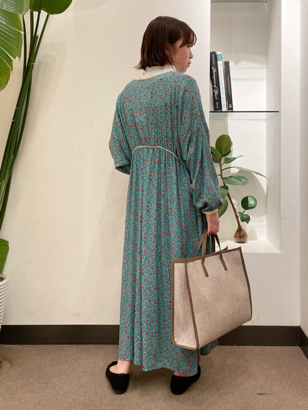 ブラック系のバレエシューズ、グリーン系のワンピース、ホワイト系のTシャツ/カットソーを着用したレディースの冬コーディネートの4枚目の写真