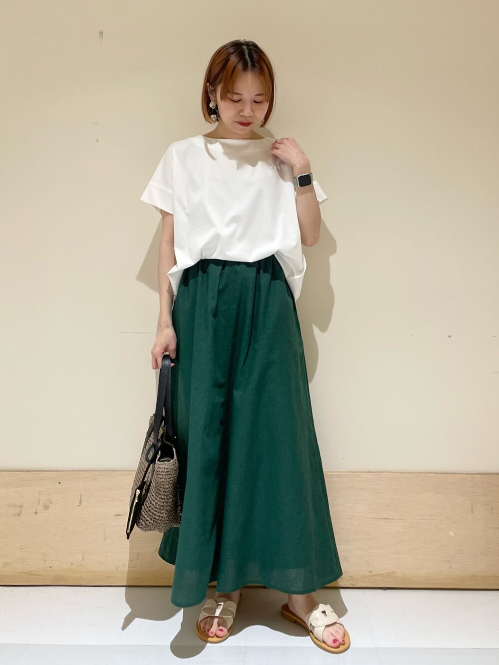 ホワイト系のTシャツ/カットソー、グレー系のトートバッグ、グリーン系のスカートを着用したレディースの夏コーディネートの3枚目の写真