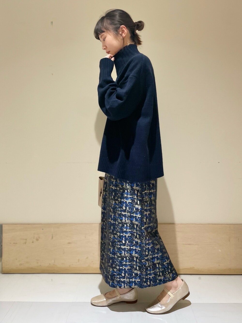 ブルー系のニット/セーター、ブルー系のスカート、ゴールド系のその他シューズを着用したレディースの冬コーディネートの4枚目の写真