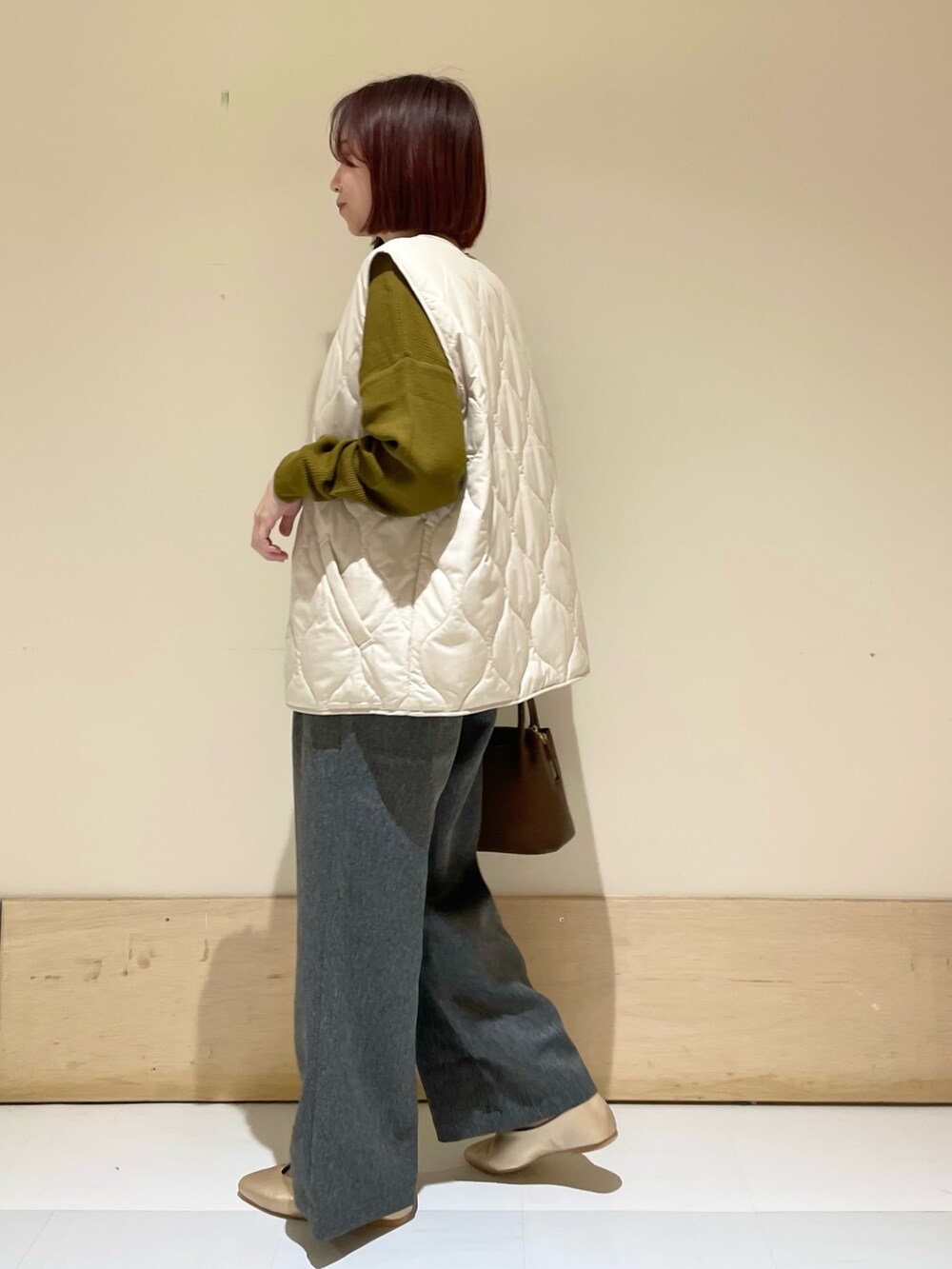 ゴールド系のパンプス、ブラウン系のショルダーバッグ、イエロー系のTシャツ/カットソーを着用したレディースの秋コーディネートの5枚目の写真