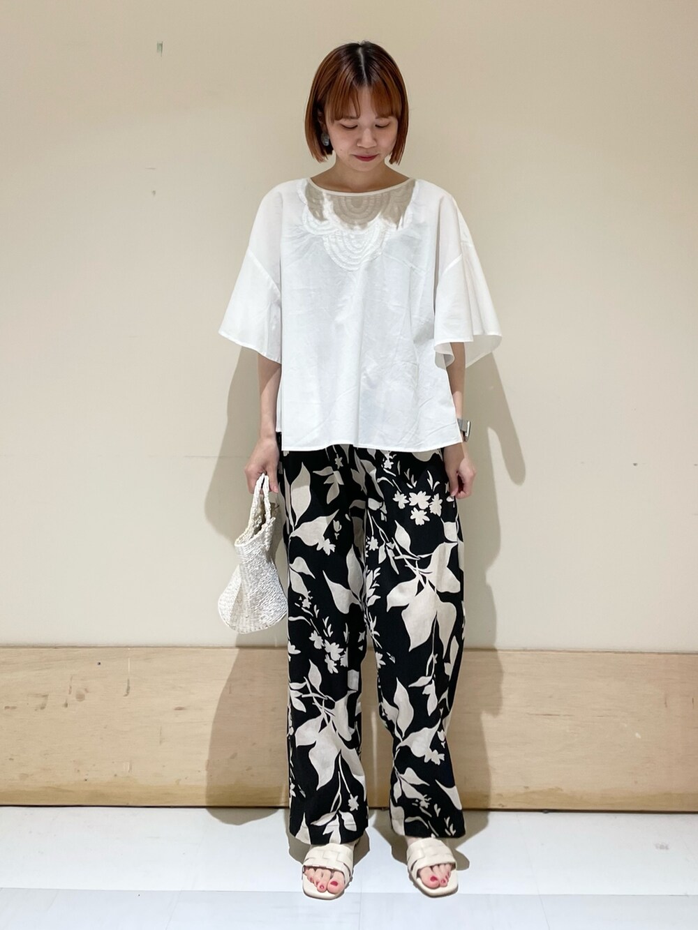 ブラック系のその他パンツ、ホワイト系のハンドバッグ、ホワイト系のサンダルを着用したレディースの夏コーディネートの2枚目の写真