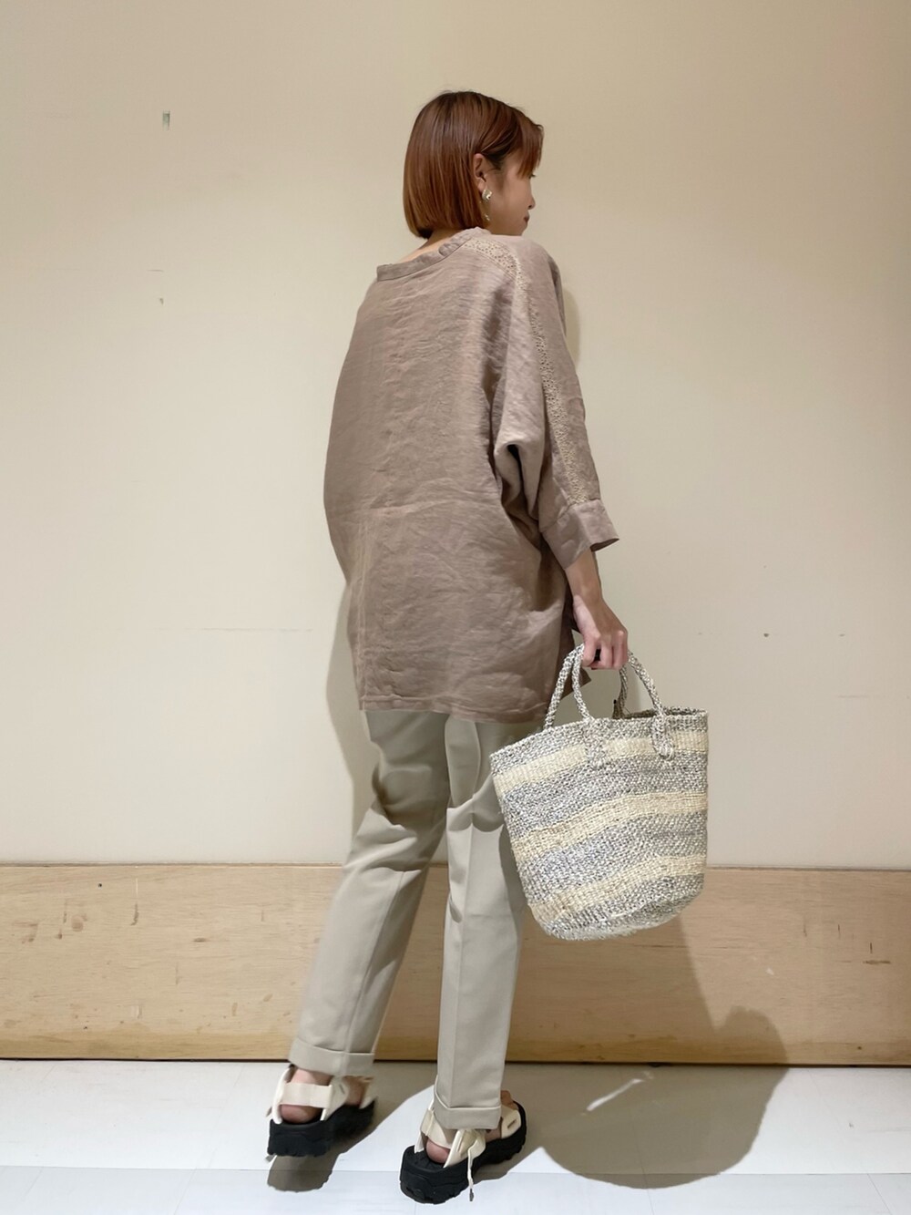 ベージュ系のその他パンツ、ホワイト系のハンドバッグ、ホワイト系のサンダルを着用したレディースの夏コーディネートの5枚目の写真