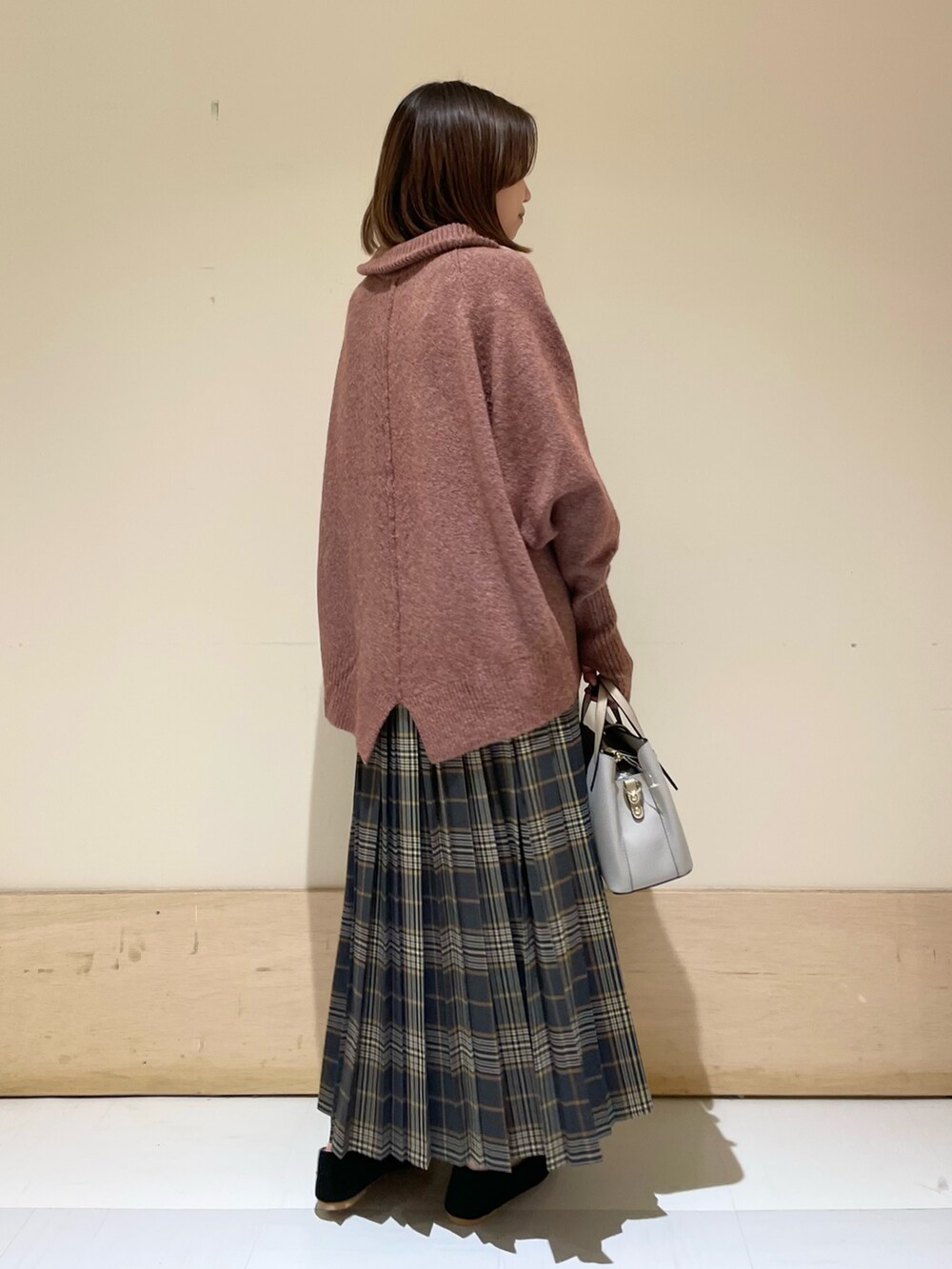 レッド系のニット/セーター、ブラック系のパンプス、グレー系のハンドバッグを着用したレディースの秋コーディネートの7枚目の写真