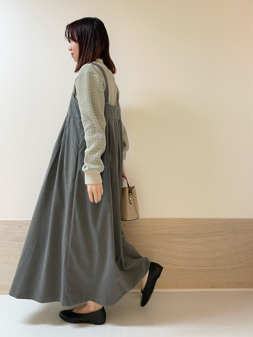 ブラック系のパンプス、グレー系のワンピース、グリーン系のTシャツ/カットソーを着用したレディースの春コーディネートの4枚目の写真