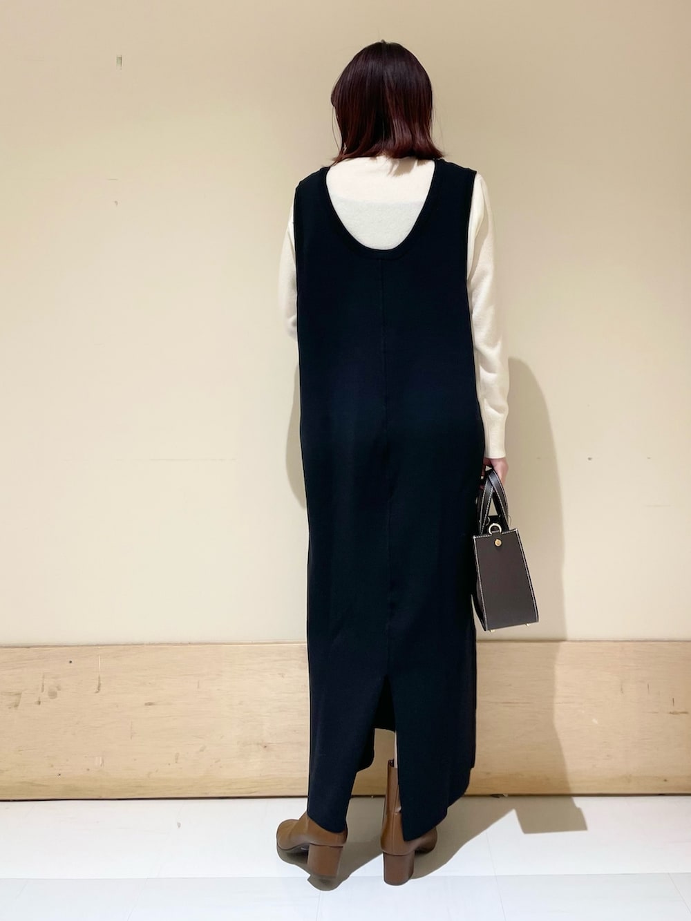 ブラック系のワンピース、ホワイト系のニット/セーターを着用したレディースの冬コーディネートの7枚目の写真