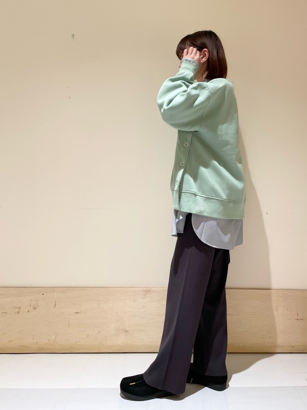 ブルー系のシャツ/ブラウス、グリーン系のスウェット、ブラック系のショルダーバッグを着用したレディースの冬コーディネートの3枚目の写真