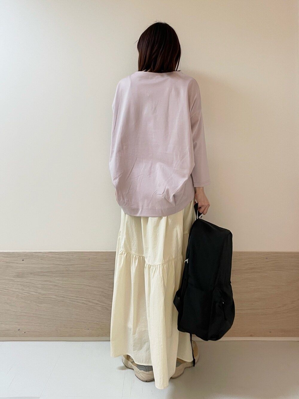 ホワイト系のスカート、ピンク系のTシャツ/カットソー、ベージュ系のスニーカーを着用したレディースの春コーディネートの5枚目の写真