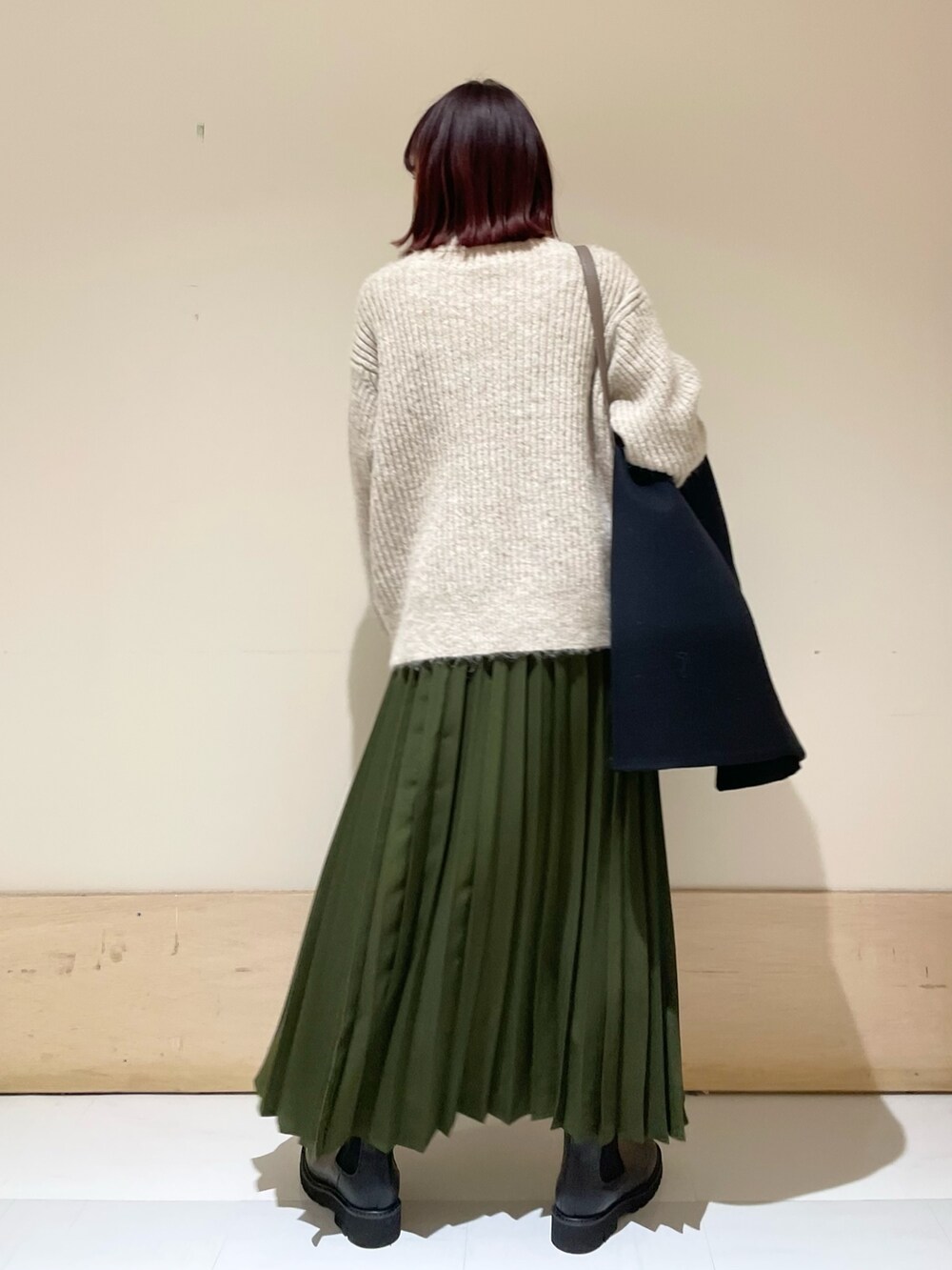 ブラック系のその他アウター、ブラック系のブーツ、グリーン系のスカートを着用したレディースの冬コーディネートの9枚目の写真