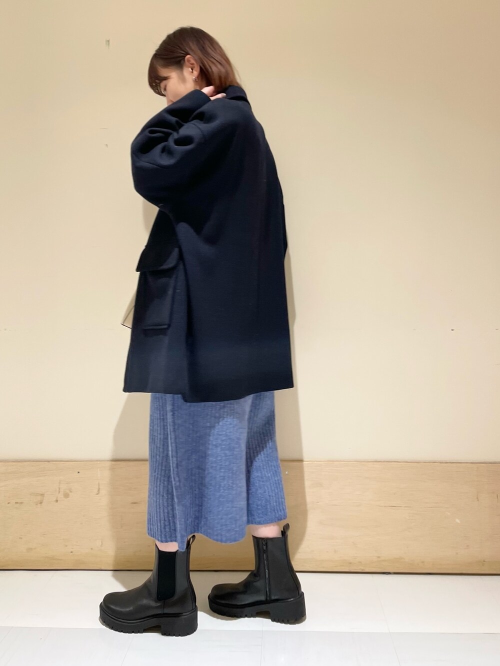 ブルー系のワンピース、ブルー系のその他アウター、ブラック系のブーツを着用したレディースの冬コーディネートの4枚目の写真