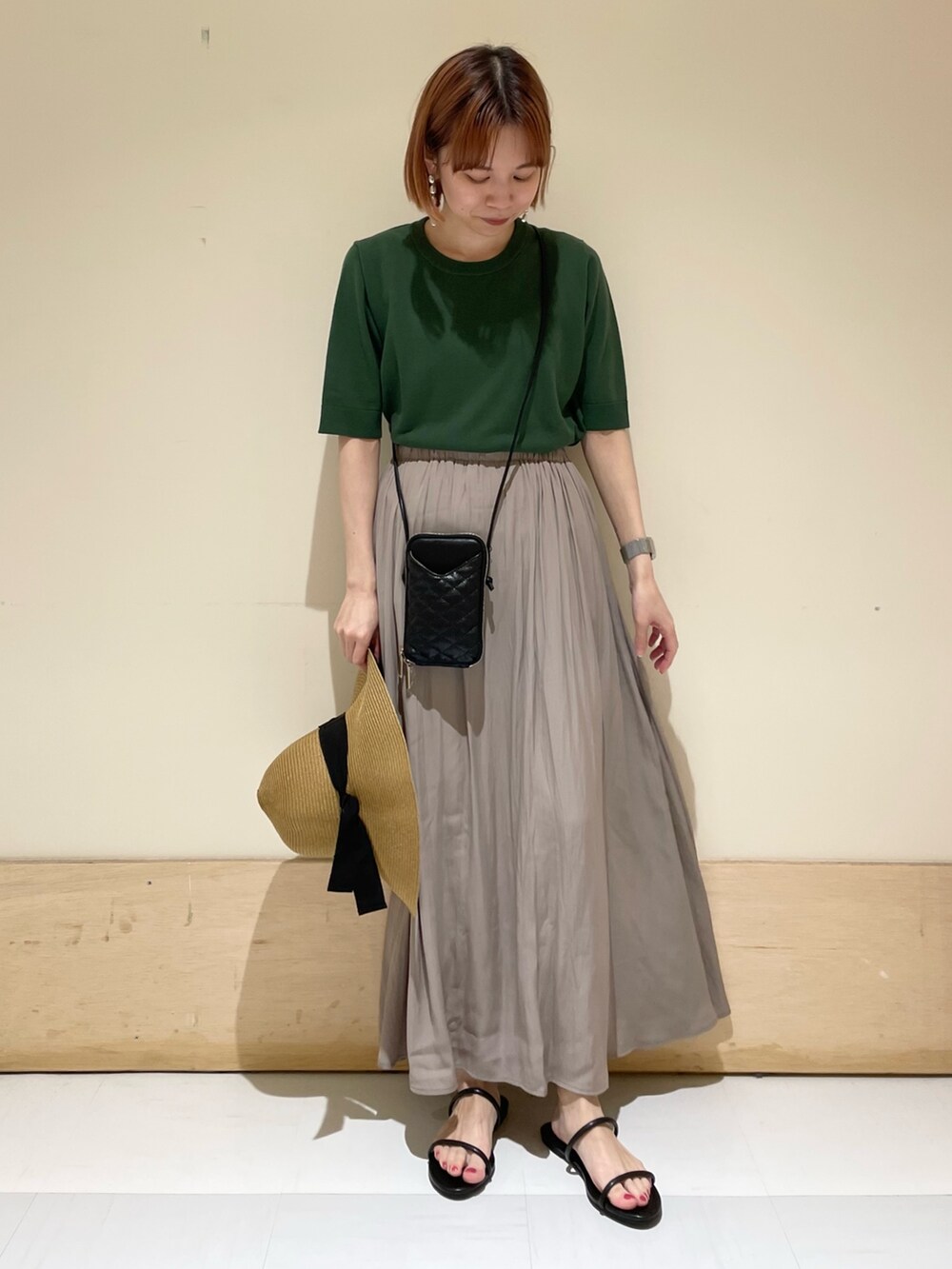 グレー系のスカート、ブラック系のサンダル、ブラック系のショルダーバッグを着用したレディースの春コーディネートの2枚目の写真