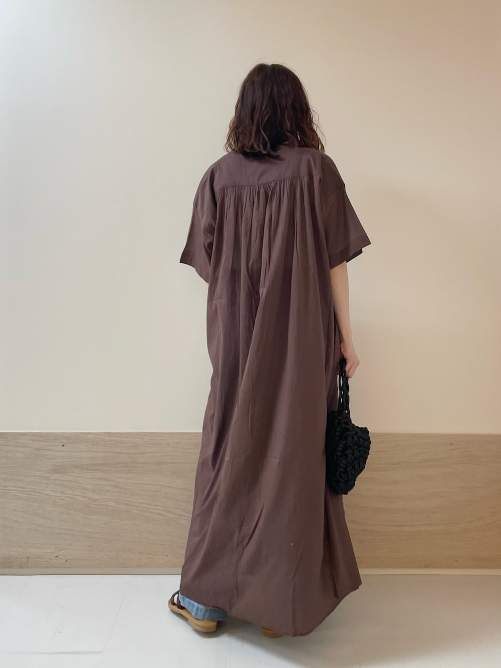 ブルー系のデニムパンツ、ブラック系のサンダル、ブラウン系のワンピースを着用したレディースの春コーディネートの9枚目の写真