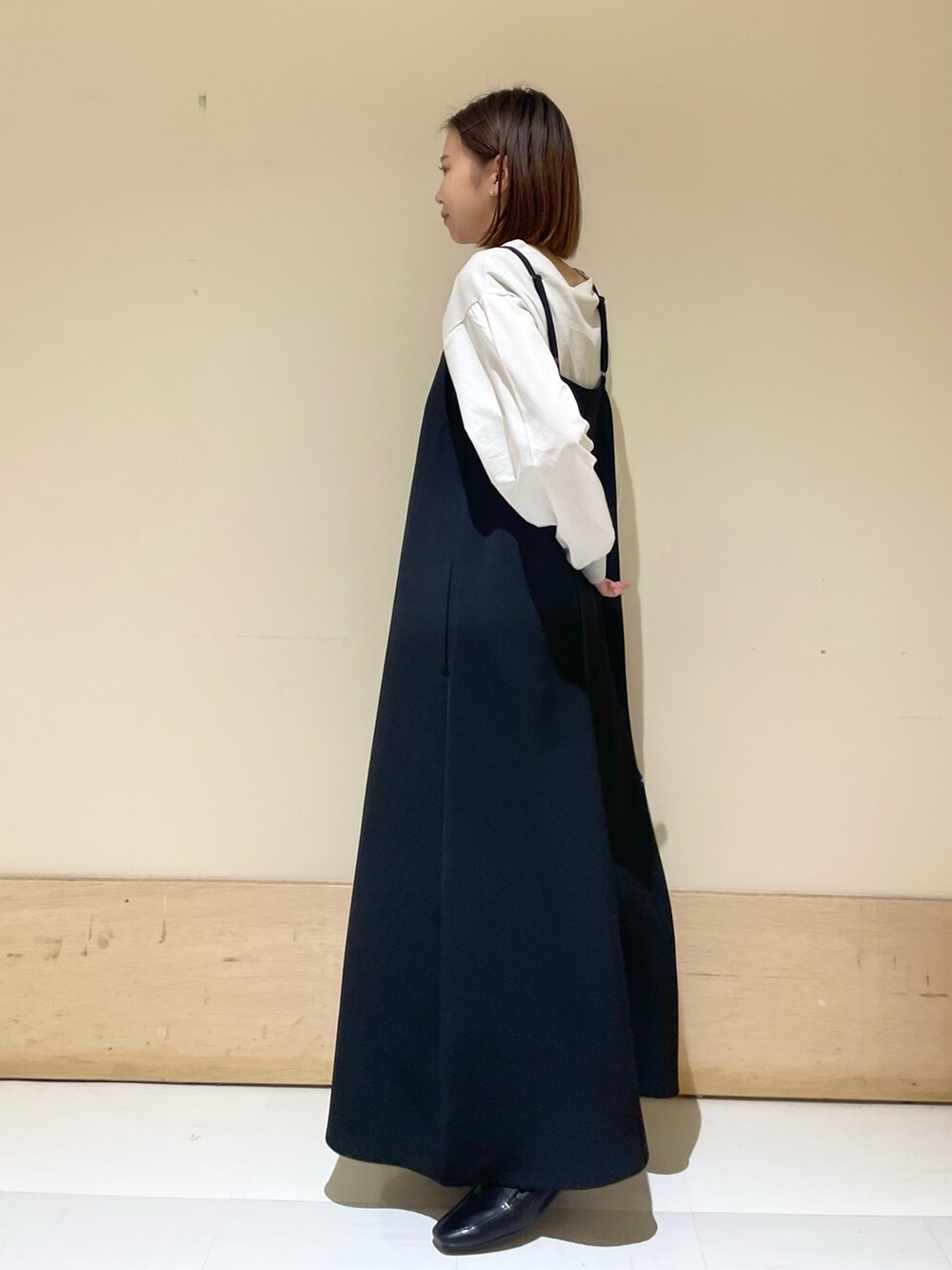 グレー系のTシャツ/カットソー、ブラック系のワンピース、ブルー系のハンドバッグを着用したレディースの秋コーディネートの4枚目の写真