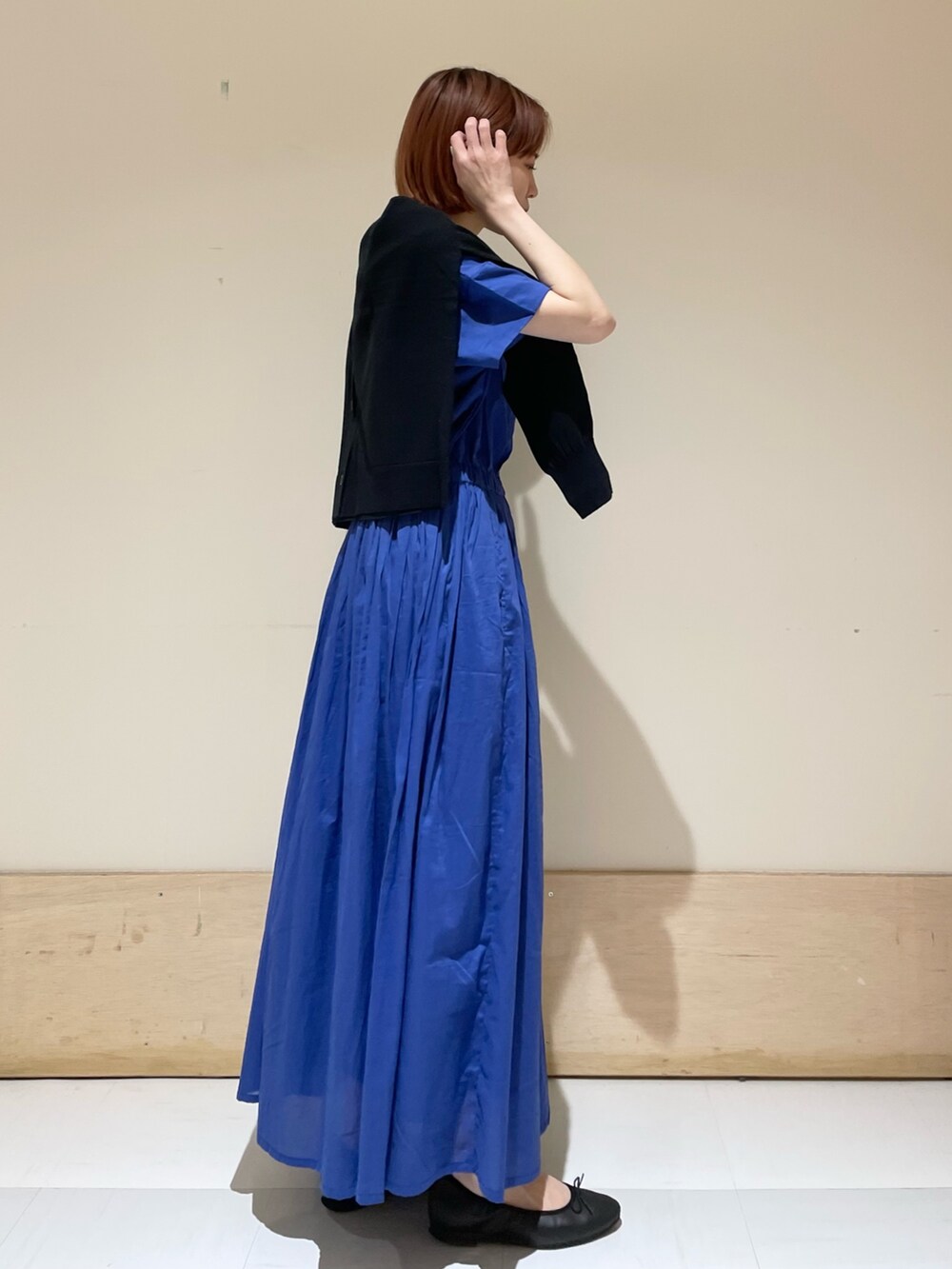 ブルー系のワンピース、ブラック系のカーディガン/ボレロ、ホワイト系のトートバッグを着用したレディースの春コーディネートの6枚目の写真