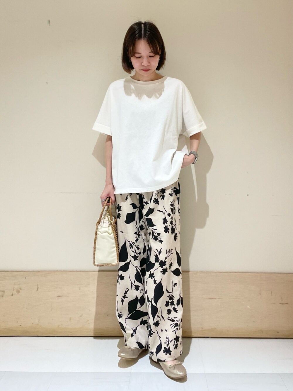 ベージュ系のその他パンツ、ホワイト系のTシャツ/カットソー、ベージュ系のハンドバッグを着用したレディースの夏コーディネートの3枚目の写真