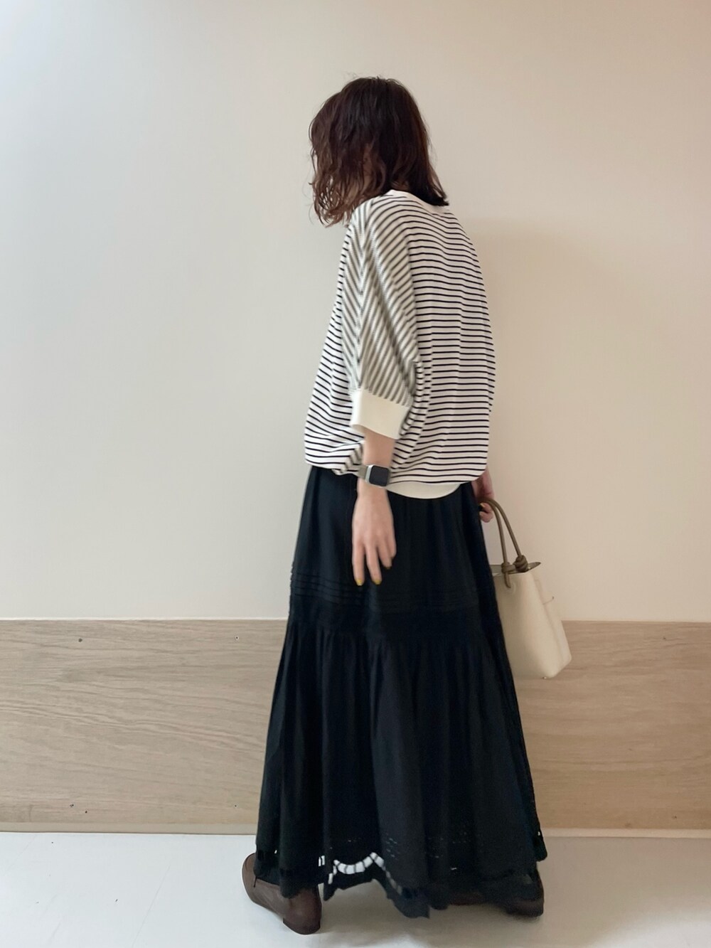 ブラウン系のローファー、ブラック系のスカート、ホワイト系のTシャツ/カットソーを着用したレディースの春コーディネートの4枚目の写真