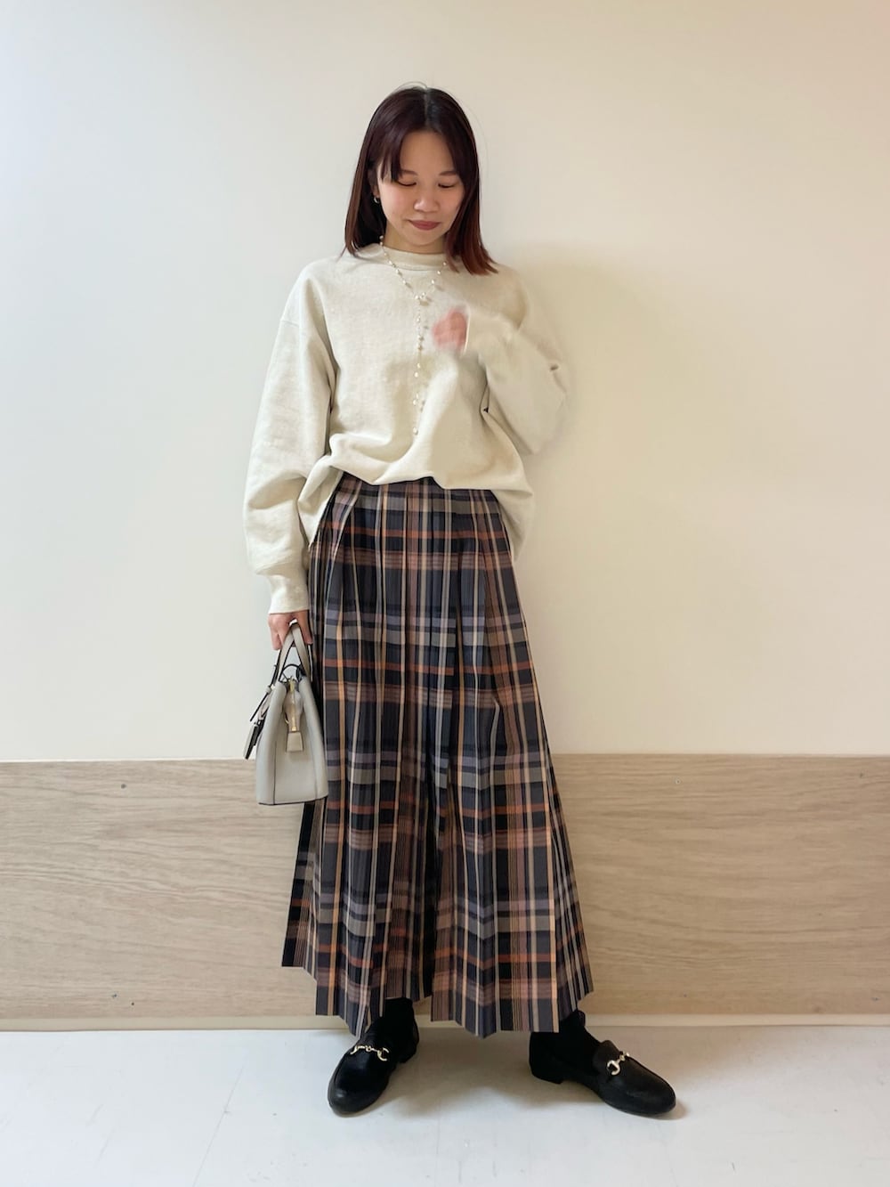 ホワイト系のスウェット、グレー系のスカートを着用したレディースの冬コーディネートの3枚目の写真