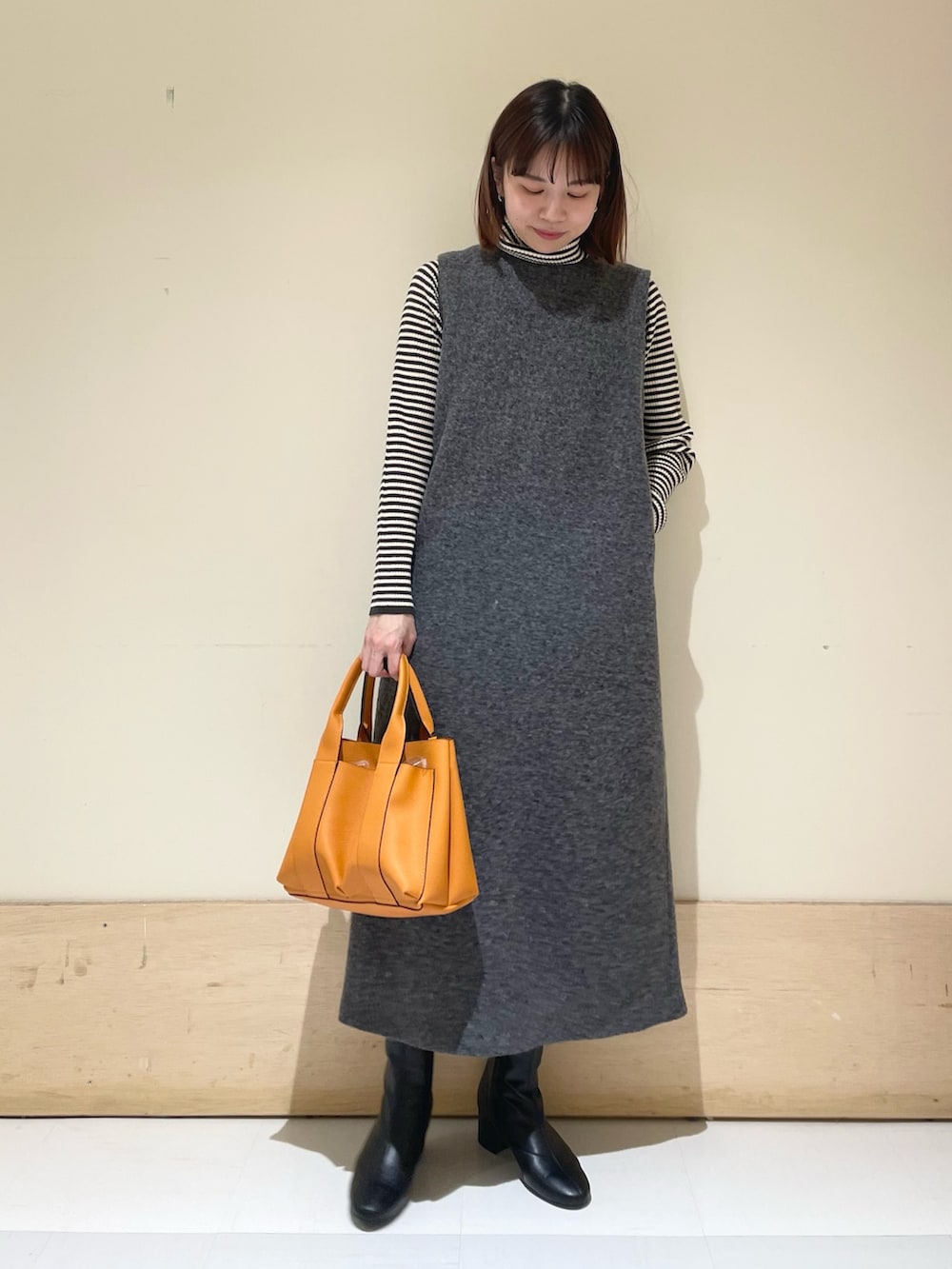 ホワイト系のニット/セーター、グレー系のワンピースを着用したレディースの冬コーディネートの3枚目の写真