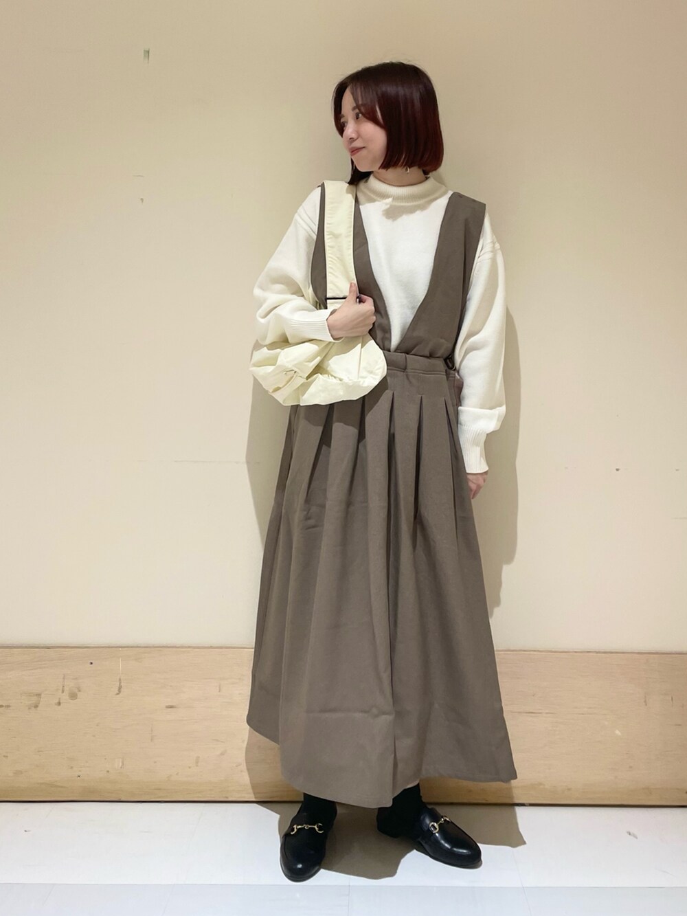 ベージュ系のニット/セーター、ブラック系のローファー、ブラウン系のサロペット/オーバーオールを着用したレディースの秋コーディネートの2枚目の写真