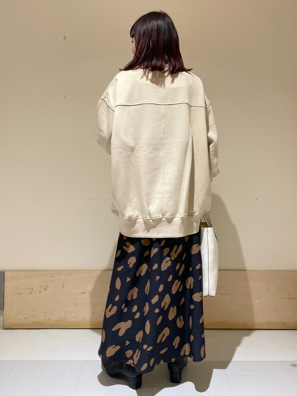 ベージュ系のスウェット、ブルー系のスカートを着用したレディースの冬コーディネートの3枚目の写真