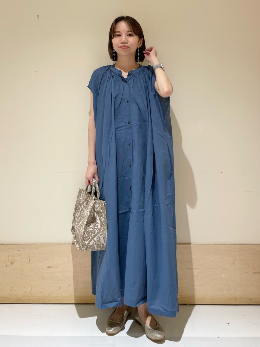 ブルー系のワンピース、ベージュ系のトートバッグ、ゴールド系のパンプスを着用したレディースの夏コーディネートの3枚目の写真