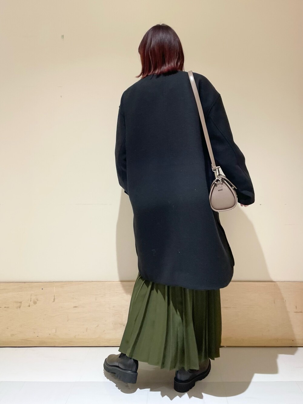 ブラック系のその他アウター、ブラック系のブーツ、グリーン系のスカートを着用したレディースの冬コーディネートの5枚目の写真