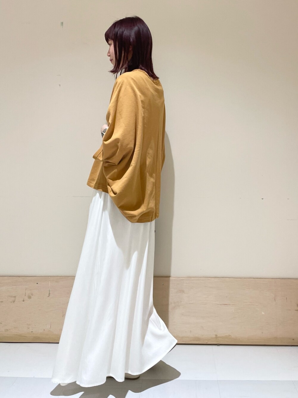 ホワイト系のスカート、イエロー系のTシャツ/カットソー、ブラック系のショルダーバッグを着用したレディースの春コーディネートの5枚目の写真