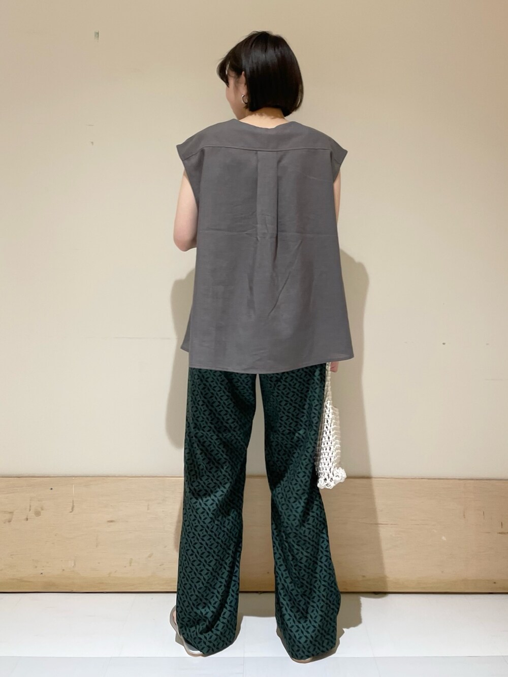 グレー系のシャツ/ブラウス、ホワイト系のハンドバッグ、シルバー系のサンダルを着用したレディースの夏コーディネートの8枚目の写真