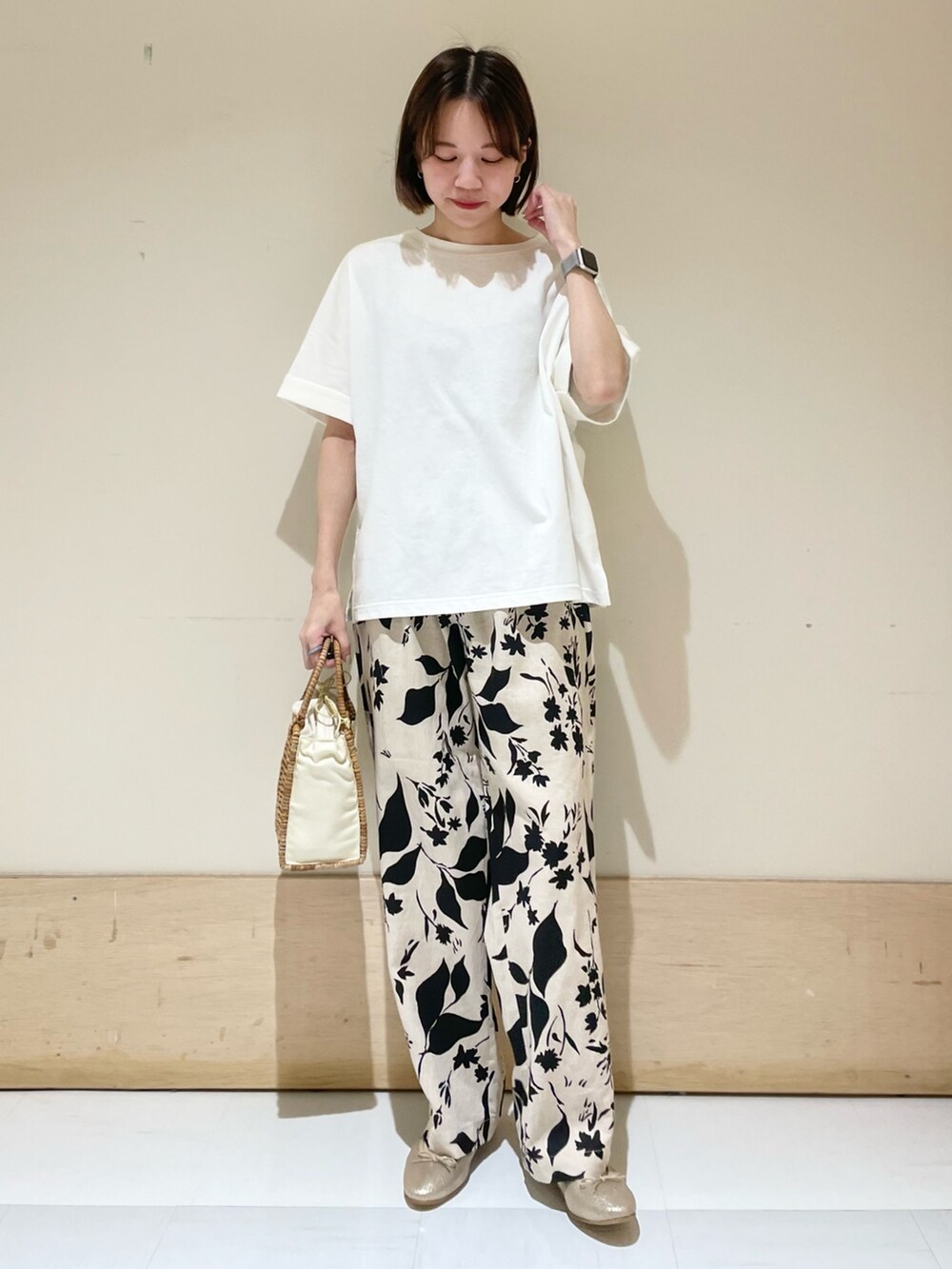 ベージュ系のその他パンツ、ホワイト系のTシャツ/カットソー、ベージュ系のハンドバッグを着用したレディースの夏コーディネートの2枚目の写真